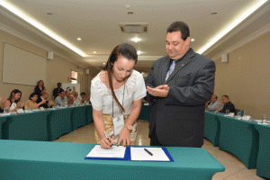 A Delegada Ildamar assina o termo de posse. 